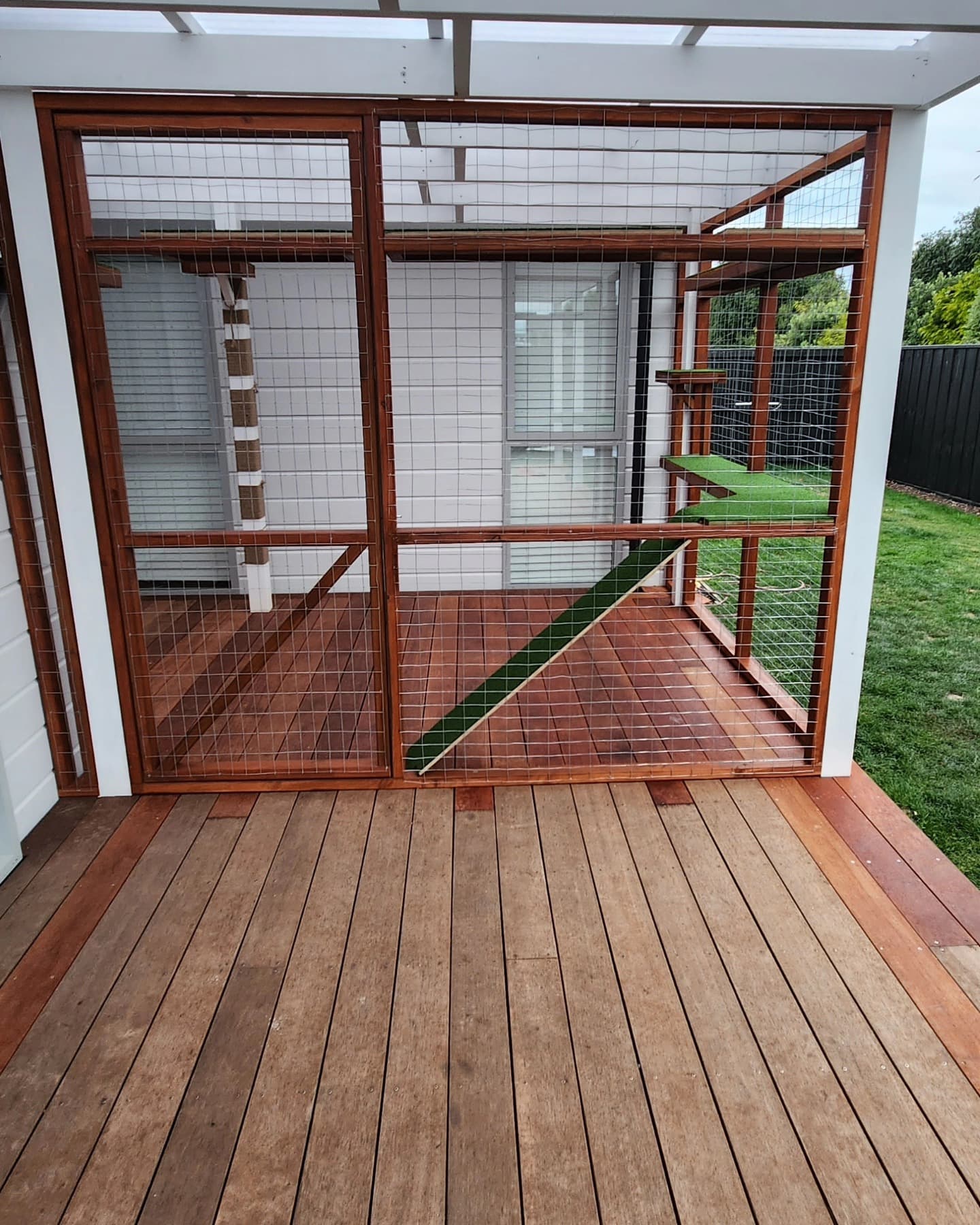Elevated catio walkway connecting house to outdoor enclosure